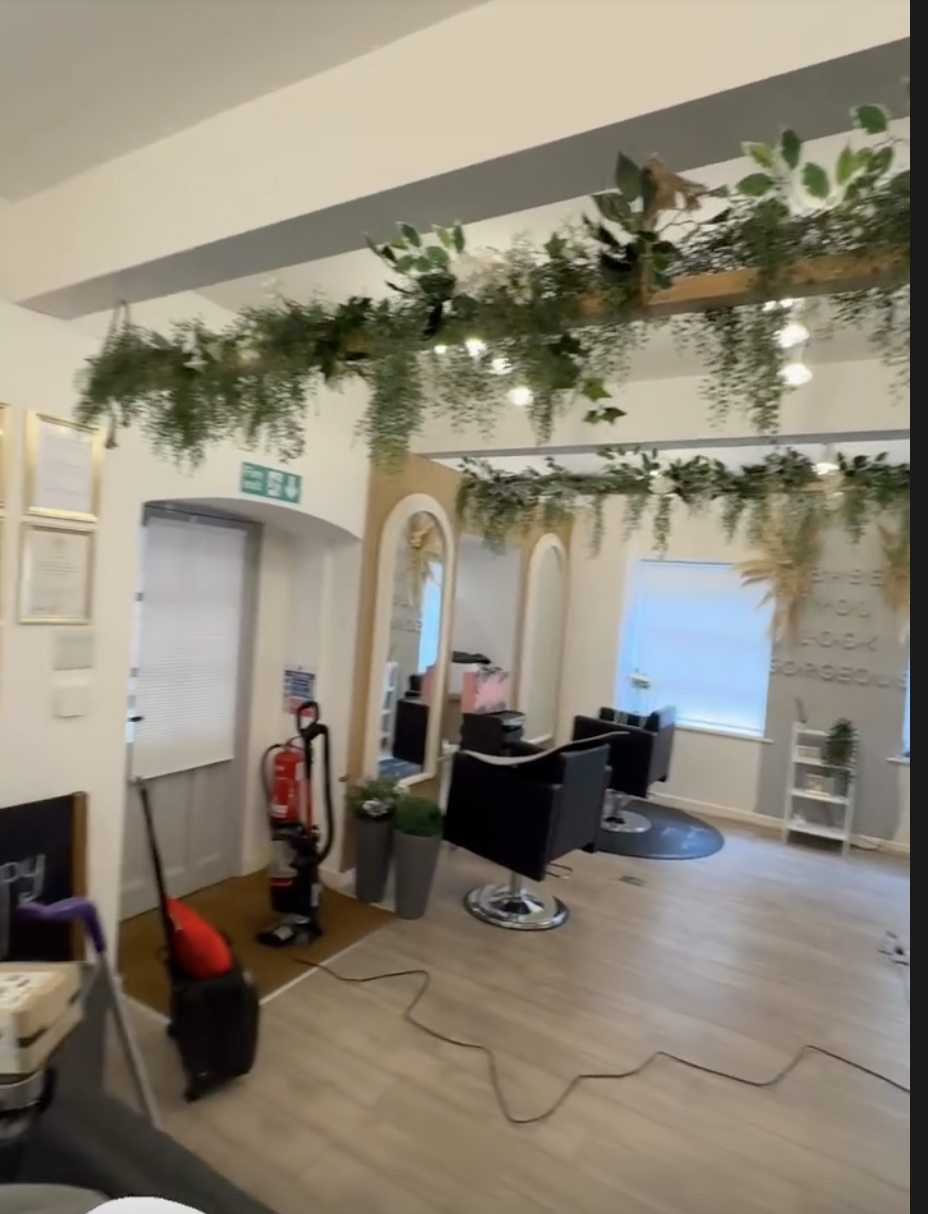 Greenery draped across the salon beams above the styling stations