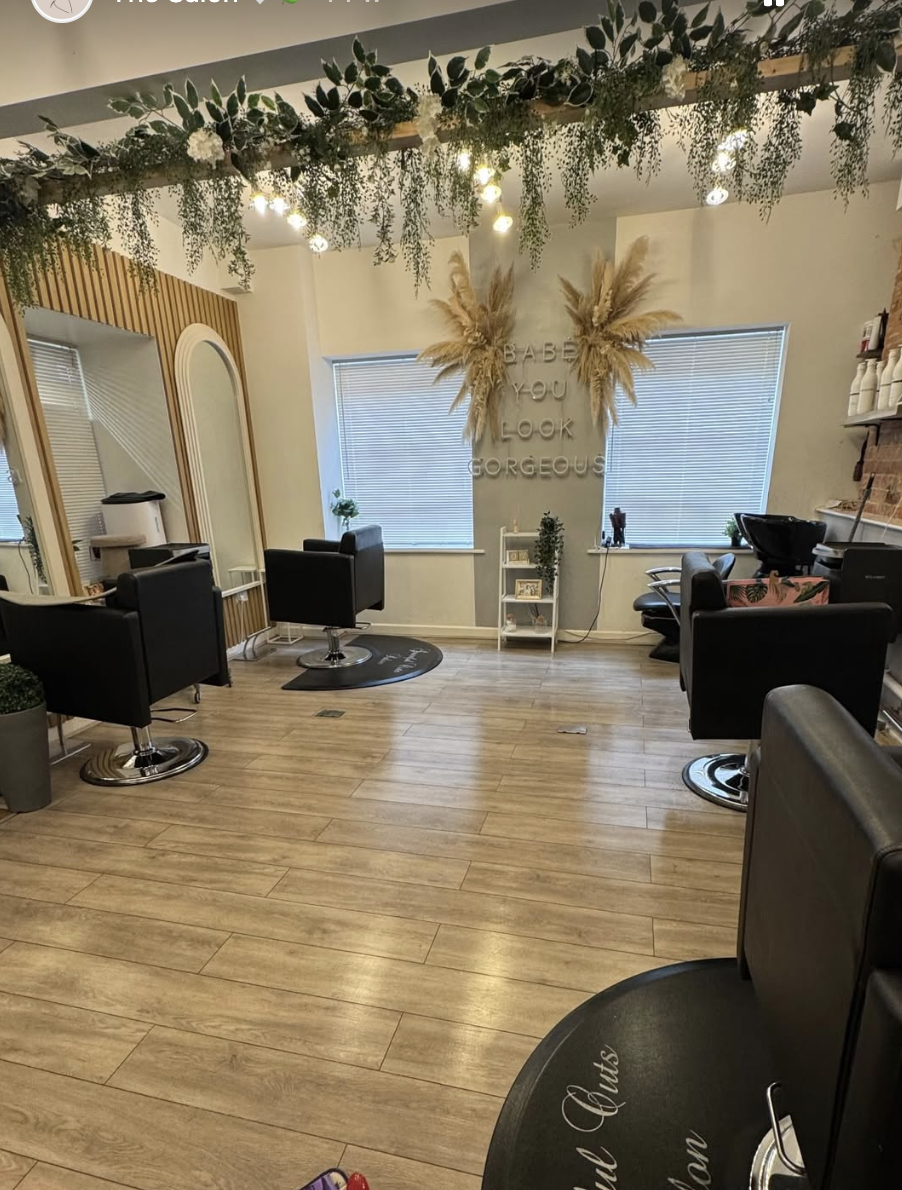 Inside Graceful Cuts — foliage, festoon lights and 'Babe you look gorgeous' on the wall