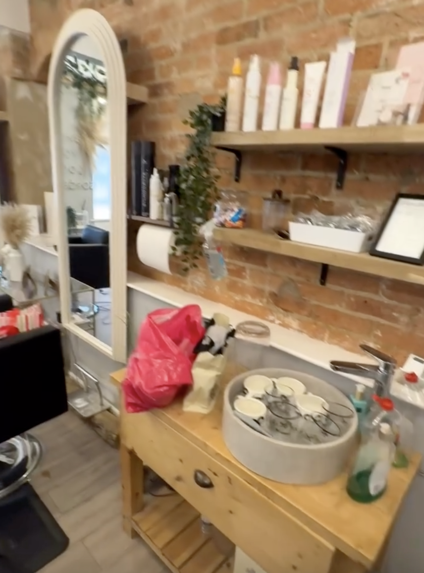 Hair products on wooden shelves against the exposed brick wall